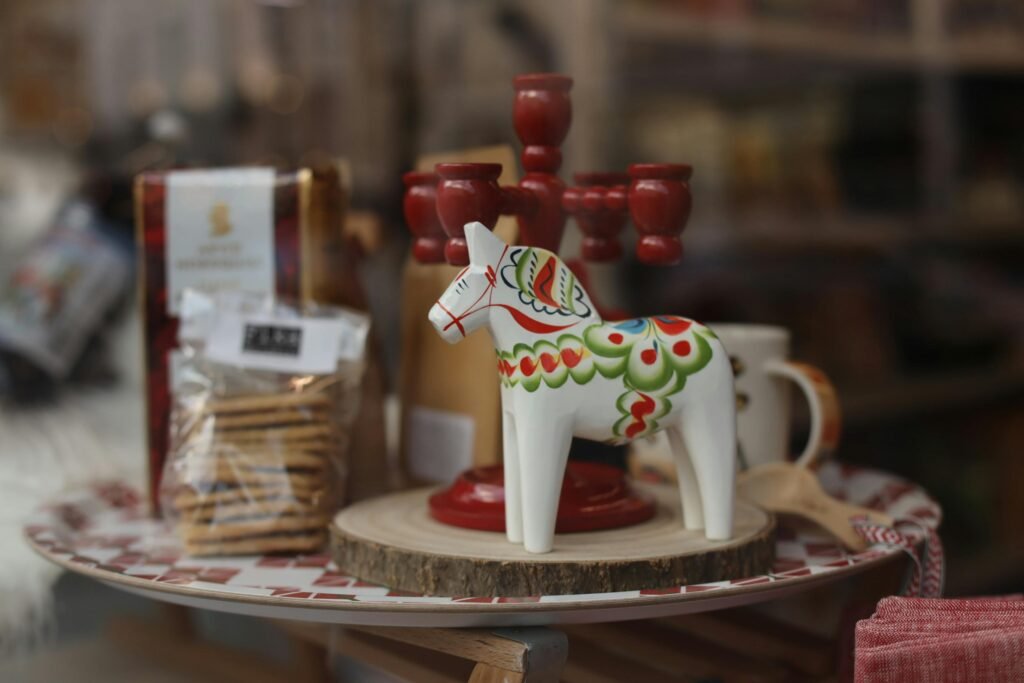 Decorative wooden ornament horse paired with red candlesticks in a cozy setting.